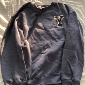Blå sweatshirt för barn  - Säljer en ganska mörk blå tröja, den är köpt från lager 157 för ungefär 1 år sen. Har använts ganska många gånger men nu har det blivit för litet för mig. Perfekt för dig som har ett namn som börjar på bokstaven Y. Den passar för barn som är 11-12 år men kan passa för barn som är 13.                                                  Observera ( kläderna kommer nytvättade till den som köper)