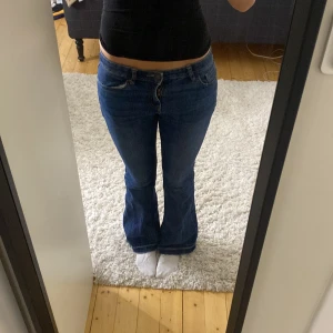 Blå bootcut jeans från Lindex - Snygga blå jeans från Lindex i modellen Freja. Jeansen har bootcut-ben och klassisk femficksdesign. De är tillverkade i bomull med en skön passform och låg midja. Perfekta för dig som gillar en retroinspirerad look.