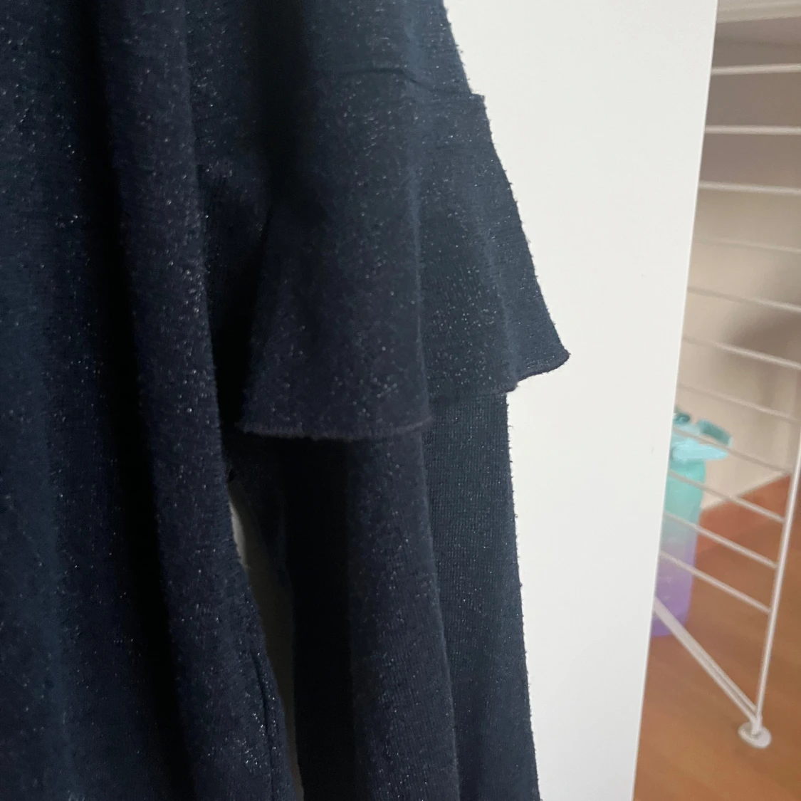 Glittrig svart tröja med volangärm - 1