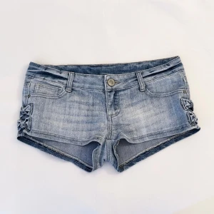 Low Rise Shorts - Super cute low rise shorts with little bows on the sides.  So flattering!  Waist: 40 cm  Length in the back: 29 cm  Length in the front: 20 cm  Please be sure to look at all photos, descriptions and always refer to measurements before buying!  Note that lighting might make a piece of clothing appear darker/lighter in photos. The colour might look different on your phone because of brightness, contrast and warmth.