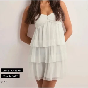 Gullig volangklänning från Nelly  - Supersöt vit kortklänning från Nelly som är använd 1 gång. Köpte här på plick å den va helt oanvänd å användes under skolavslutning. Inga skador ser helt ny ut. Storlek xs men passar mig med S. Pris går att prata om💞