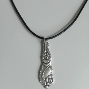 Halsband gjord av gaffel - Handgjort halsband gjord av en gaffel i nysilver. Hänget är ca 4cm lång. Kedjan på halsbandet är justerbart. Blir en unik accessoar 