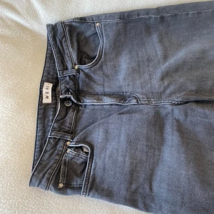 Grå jeans från Wera med raka ben - Snygga grå jeans från Wera med klassisk femficksdesign och raka ben. Jeansen har normalhög midja och är tillverkade i mjukt bomullstyg med en hint av stretch för extra komfort. Perfekta för en avslappnad och stilren look.