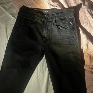 Svarta jeans från Replay - Ett par svarta jeans från Replay med klassisk design. Jeansen har fickor både fram och bak. Tyvärr har lappen slitits av på baksidan som ni ser på andra bilden. Storlek (31/34)