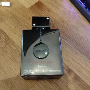 Armaf Club de Nuit Intense Man Parfum - Snygg parfymflaska i svart glas med metallisk detalj och kedja framtill. Limited Edition av Club de Nuit Intense Man Parfum, 105 ml. Flaskan har en modern, fyrkantig design och känns riktigt lyxig. Tillverkad i Dubai, U.A.E. använt max 15ml