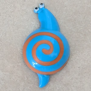 Blå snigel magnet med spiral - Cool magnet formad som en snigel i blå plast med orange spiral på skalet och två utstickande ögon. En magnet med en lekfull och färgstark touch. Magneten har en tydlig och unik design som sticker ut.