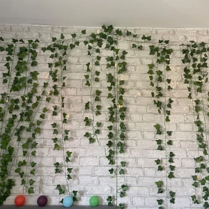 Gröna konstgjorda murgröna med ljusslinga - Säljer en dekorativ murgröna i konstmaterial med tillhörande batteridriven ljusslinga. Slingan har små varmvita LED-lampor som ger mysig stämning. Perfekt för att skapa en chill vibe i rummet med gröna blad som hänger ner längs väggen. Det är 12 längder och varje längd är 2,2 meter! Skriv för fler bilder/ frågor 💕