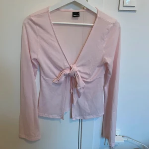 Ljusrosa omlottopp från Gina Tricot - Säljer en ljusrosa omlottopp från Gina Tricot i mjuk bomull🥰 Slutsåld på ginas hemsida, använd endast ett antal fåtal gånger. Pris kan disskuteras💕