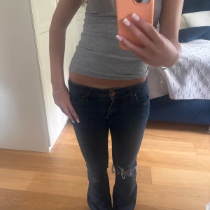 Blå bootcut jeans med slitning - Säljer ett par blå bootcut jeans med låg midja från Next. Jättebra skick. Storlek S men passar både S och XS