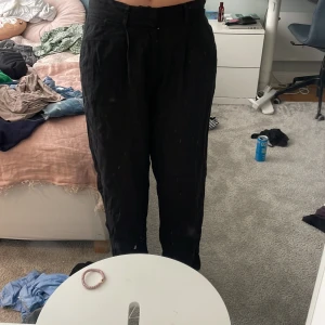Svarta linnebyxor från Gina Tricot - Säljer ett par svarta linnebyxor från Gina Tricot i storlek S. Byxorna har hög midja, raka ben och en avslappnad passform. Perfekta för en chill och stilren look. Materialet är svalt linne som ger en skön känsla hela dagen. Har aldrig använts