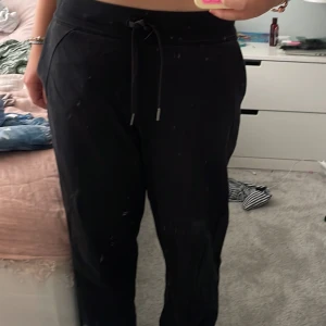 Svarta mjukisbyxor från Lululemon - Svarta mjukisbyxor från Lululemon med dragsko i midjan och bekväm passform. Byxorna har diskret logga på benet och är perfekta för chill eller träning. Tillverkade i mjukt och stretchigt material för maximal komfort. Har använts ett fåtal gånger. Pris kan diskuteras💗