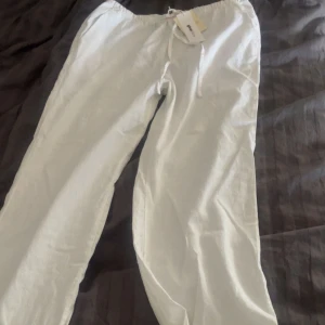 Vita linnebyxor från Gina! - Säljer ett par fräscha vita linnebyxor från Ginatricot med dragsko i midjan. Byxorna har en avslappnad passform och är perfekta för varma dagar. Lätta och luftiga med klassisk look. Säljer då dem ej är använda alls. De har lappen kvar. Originalpris - 400