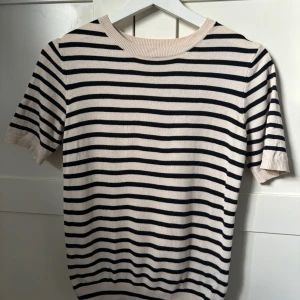 Randig kortärmad tröja från H&M - Säljer en beige och svart randig tröja från H&M. Tröjan har korta ärmar och rund halsringning. Endast använd ett fåtal gånger💞😊