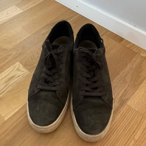 Vagabond skor - Bruna sneakers från Vagabond med snörning. Skorna har en platt, vit/bege sula och är tillverkade i mocka. Perfekta till sommaren och hösten nu. Har en liten diffekt som jag tog bild på. Priset är inte hugget i sten. 