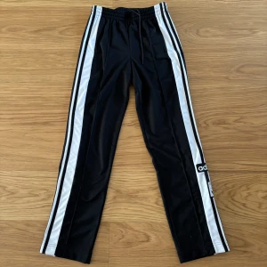 Adibreak - Adidasbyxor - Säljer ett par Adibreak Adidasbyxor som knappt är använda. Lös passform. Elastisk midja med dragsko. 100 % polyester (återvunnen).  Sidofickor. Sidopaneler med tryckknappar. Ord. pris: 849 kr. Mitt pris: 600 kr
