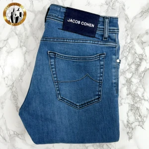 Jacob Cohën 33 - Blåa Jacob Cohën Nick Slim/622 jeans i storlek W33 i mycket bra skick. Dessa är av den senaste ”generationen” Jacob Cohen jeans och har därav de nya lapparna innantill. Lappen baktill är något skavd i kanterna (se bild). Jeansen har inga lagningar eller andra skavanker och är i otroligt bra skick. Tveka inte på att höra av dig för fler bilder eller vid minsta fundering! Självklart äkta. Skick: 9/10 | Mått A: 42cm | Mått B: 105cm | Mått C: 84cm 