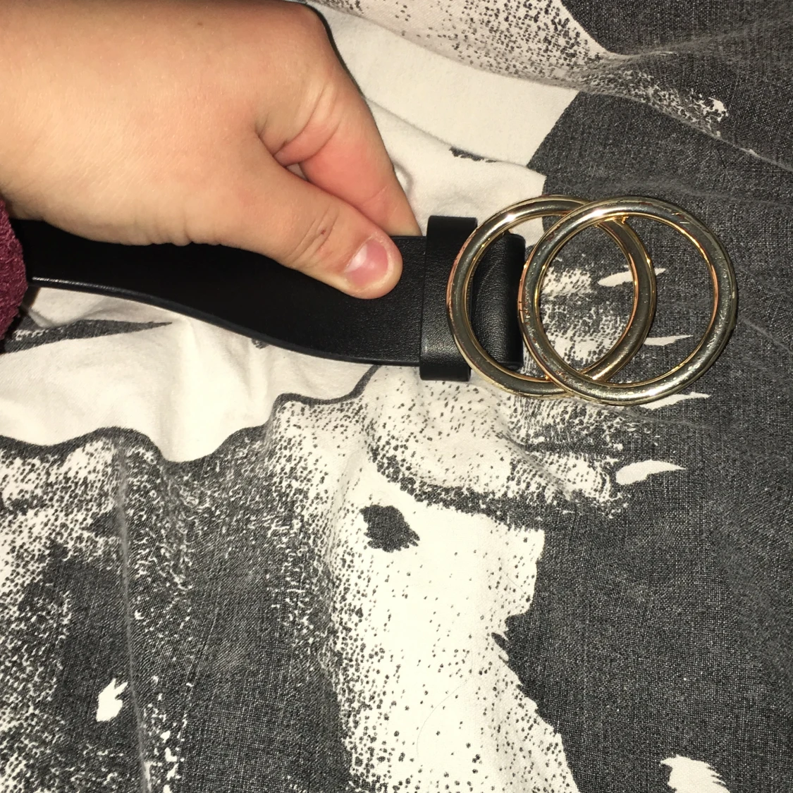 Svart bälte med dubbla guldringar