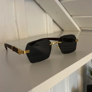 Solglasögon  - Säljer dessa riktigt feta solglasögonen! De har en snygg combo med guld och mörkt trä på sidorna! Säljer pga att de aldrig kommer till användning. Priset kan sänkas vid snabb köp!