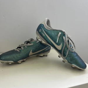 Nike fotbollsskor i blått och vitt - Säljer ett par Nike fotbollsskor i blått med vita detaljer och snörning. Storlek 42. Priset går att diskutera, kontakta för frågor!