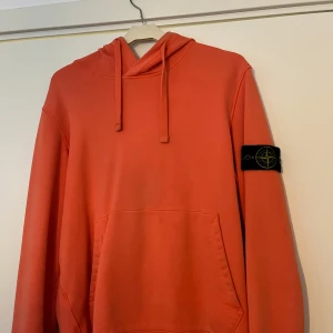  Stone Island hoodie - Säljer en orange hoodie från Stone Island med klassisk patch på vänster ärm. Tröjan är i fint skick! 