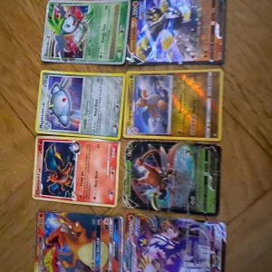 Pokémonkort (blandade) - Ett set med olika Pokémonkort, inklusive flera holografiska och sällsynta kort. Perfekt för samlare eller dig som vill bygga en stark kortlek. Korten har färgstarka illustrationer och varierande krafter – en rolig mix för alla Pokémonfans!