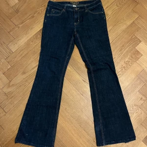 Mörkblå bootcut jeans - Mörkblå Jeans från Arizona. Lågmidjade och bootcut    Ungefärliga mått: Midja platt: 40cm Innerben: 80cm Hel längd: 105cm  Har heelbite och saknar nederkantssöm