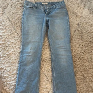 Ljusblå Levis jeans med bootcut - Säljer ett par klassiska ljusblå Levis jeans med låg midja och bootcut. Jeansen har fem fickor, dragkedja och knapp framtill samt Levis-logga bak. Perfekta för dig som gillar en tidlös denimlook.