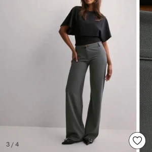 Grå vida kostymbyxor - Snygga grå kostymbyxor med låg midja och vida ben. Byxorna har klassisk passform med dragkedja och knapp framtill. Perfekta för en stilren och trendig look. Aldrig använda❤️