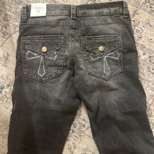 Gina Young jeans HELT NYA! OBS läs beskrivning - Helt oanvända mörkgråa utsvängda lågmidjade jeans med ”vintage look” och fina detaljer på bakfickorna med glitter/paljetter. Storlek XS/164. Med prislapp kvar💕 ‼️Kan även tänka mig att byta mot likadana i storlek 170‼️