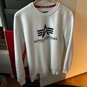 Vit sweatshirt från Alpha Industries - Säljer en mjuk vit sweatshirt från Alpha Industries. Inga defekter alls, tvättar strax innan ett eventuellt köp så att de lite missfärgade i nacken försvinner. Passar S