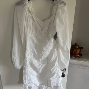 Klänning - Klänning från Nelly i storlek 34 med prislapp på som köptes till konfirmation för 2 år sedan men kom aldrig till användning