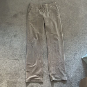 Juicy Couture byxor - Säljer ett par beige juicy couture mjukisbyxor. De är väl använda därav priset. Har även tappat en liten del vid snörningen. Annars supersköna byxor och perfekt till vardags!