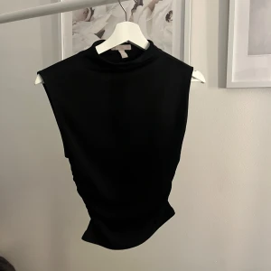 Svart topp - Snygg svart topp utan armar med indragningar i midjan ❤️‍🔥 Använd fåtal gånger, jättefint skick. Skriv meddelande vid frågor/fler bilder 🤩