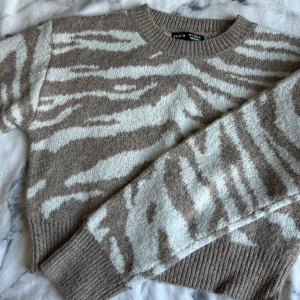 Stickad tröja från SHEIN - Säljer en stickad tröja från SHEIN i beige och vitt med zebramönster. Använd kanske 4 gånger🤎