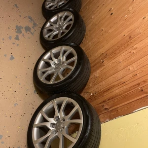 Audi originalfälgar med däck 18 tum - Säljer fyra stycken original Audi aluminiumfälgar med däck. Fälgarna är 18 tum och har en modern, sportig design med flera ekrar. Däckdimensionen är 245/40 ZR18. Passar perfekt till Audi-bilar. 8mm kvar av däck mönstret nästan nya