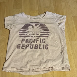 3 olika T-shirts  - Säljer en beige t-shirt med tryck av palm och texten 'Pacific Republic' på bröstet. T-shirten har rund halsringning och korta ärmar. Perfekt för en avslappnad stil. Sedan en grön T-shirt från vero Moda. Och en svart u-ringad T-shirts från lager157 som är storlek S. Dom andra storlekarna är xs. 