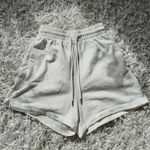 Vita mjuka shorts - Superbekväma högmidjade vita shorts från H&M i mjuk bomullsblandning. De har elastisk midja och avslappnad passform. Perfekta för varma dagar eller som chill-plagg hemma. Hör av dig vid frågor! 💕