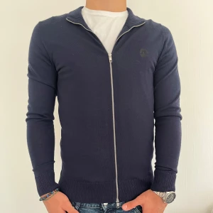 Mörkblå ziptröja från J.Lindeberg - Tja! Säljer min zip tröja från J.Lindberg pga att jag inte har användning för den längre. Den har inga defekter eller liknande och är i väldigt fint skick. Storleken är M men sitter bättre på en S anser jag. Nypris runt 800kr. Tveka inte på att höra av er vid minsta lilla fundering!