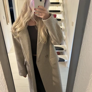 Beige kappa - Säljer denna beiga oversized kappan i ullmix från nakd. Har frf lappen kvar säljer då den är för stor för mig. Storlek 34. Är 164 cm, skulle rekommendera att man är över 170 då den är för lång på mig❤️❤️