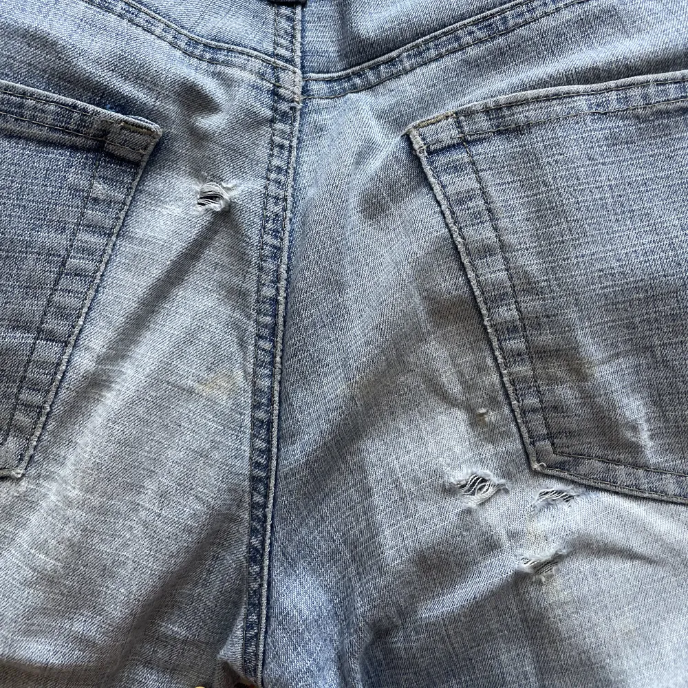 blå lågmidjade bootcut jeans med lite slitnaste i rumpan men inget som syns när man använder dom . Jeans & Byxor.