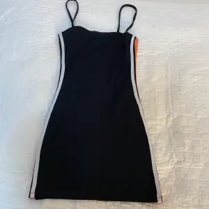 Väldigt kort klänning från H&M och är orange o vit på sidorna av klänningen. 