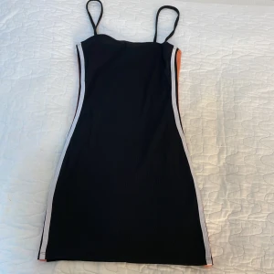 Kort klänning - Väldigt kort klänning från H&M och är orange o vit på sidorna av klänningen. 