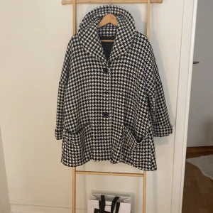 Kappa  - Fin kappa, okänt märke, svart och vit (hundtandsmönstrad). Oversize modell, mysig och ledig i modellen. Str ca 36, liten 38. Hämtas på Gärdet eller i inne i stan. Alt skickas. 