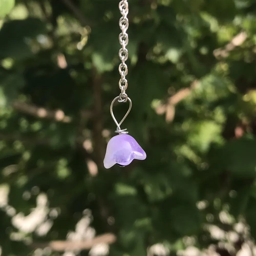 Lila halsbandshänge av glasblomma, silveromfattning och  fossilsten. Nytt oanvänt och handgjort. Finns också i fler färger på min profil🌺kontakta gärna vid frågor☺️. Accessoarer.