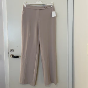 Beiga kostymbyxor, Helt ny - Säljer dessa snygga och eleganta beiga kostymbyxor. De är endast testade och har prislapp kvar!