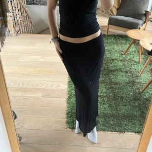 Lång svart kjol - Lång svart kjol, inget märke. Mjukt och stretchigt material! Jag är 176cm och den är så lång som på bilden när jag har den lowwaist🖤
