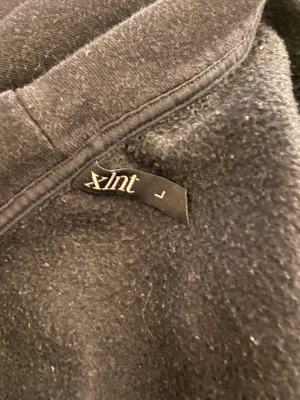 Svart hoodie  - Svart hoodie med en guldig dragkedja i storlek L
