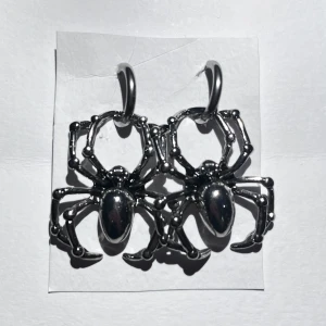 spindel örhängen - ett par jättecoola spindel örhängen 🕷️ ungefär 4 cm långa och är i silver, förmodligen någon blandning av fake silver (lite magnetiskt) men är köpta från h&m tror jag och är i fin kvalitet. frakt 18kr med swish, eller använd köp nu!