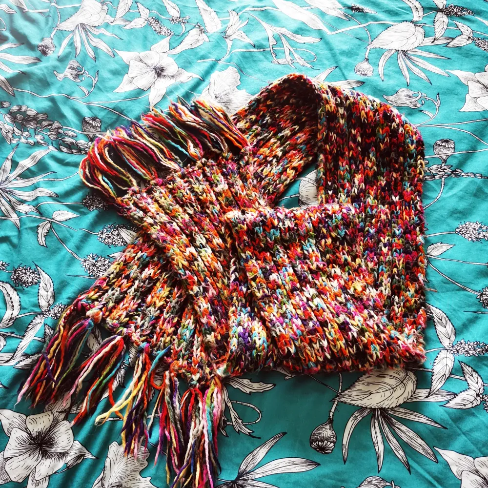 Multicolored scarf. Hand knitted. Signs of wear but still in good condition . Övrigt.