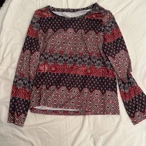 Långärmad tröja med mönster - Långärmad tröja med jättefint mönster! Supersnygg att ha bakåtfram också! Den är i sim/träningskläder material, väldigt mjukt och bekväm🙌 Står ej strl men gissar ungefär S/M utifrån min storlek och hur den sitter när jag har på mig den!😌